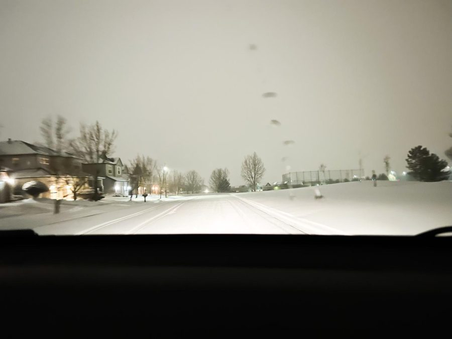 A picture of snowy roads at night. Something the school district would see when trying to determine a snow day