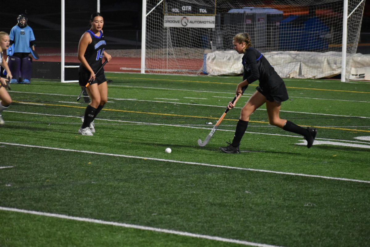 Caroline Ryan(12) pushes the ball up the field for her team