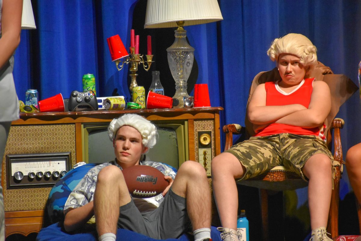 Juniors Riley Hale (left) and Nora Khalilian (right) sit as their peers are performing in their Founding Frat Brothers set.