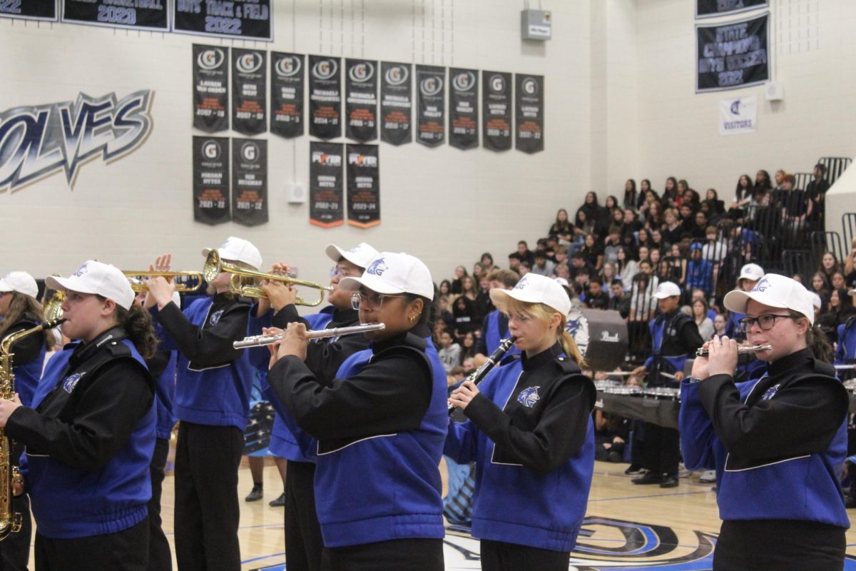 The marching band performs various popular songs at the Pep Rally.