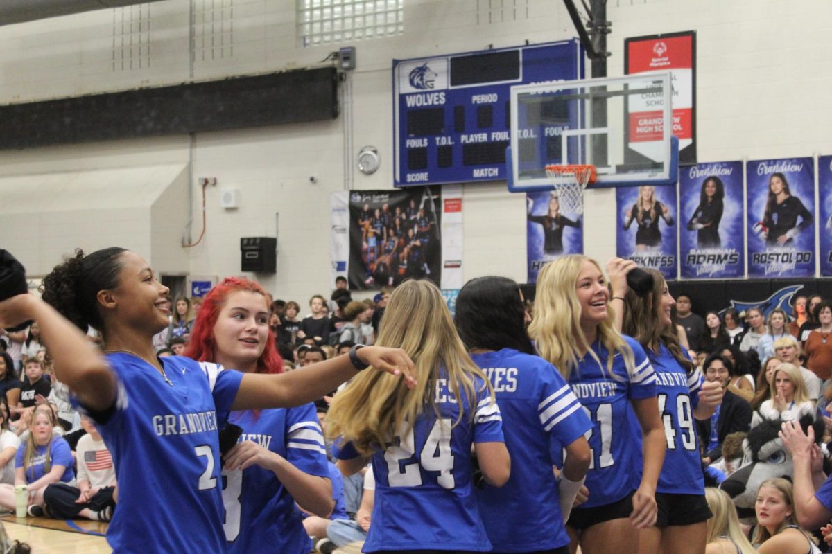 The Girls Flag Football team captains throwing shirts at the senior section while all the team captains are being announced.