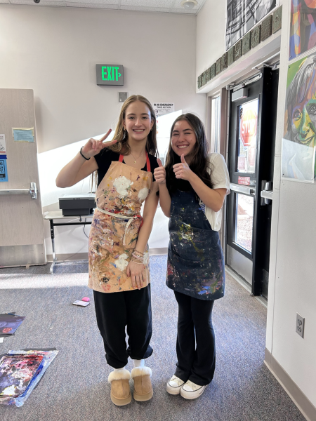 Emma Ault (Right) and Addi Harris (Left) pose for a photo for Athlete of the Week during art class. 