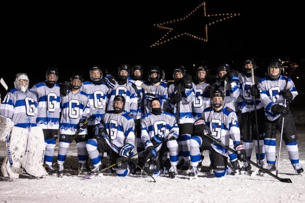 The 2024-25 Wolves Hockey team poses under the bright bulbs in the Palmer Lake Star as the backdrop to the PLOC.
