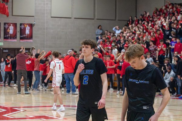 Noah Sevy (11) (left) walks off of the court after losing to Regis