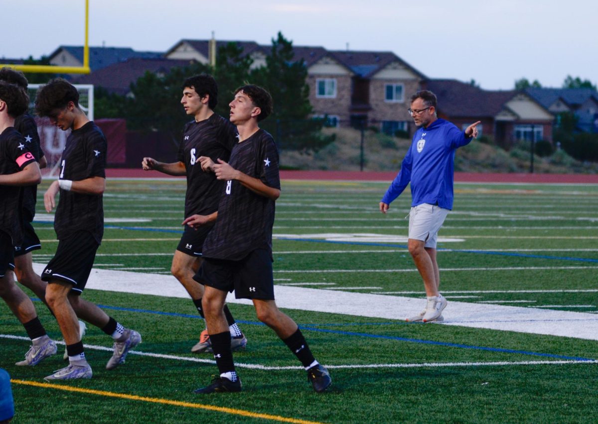 Coach Watts leads the team through a quick warm up before the start of the second half of their home game against Valor.
