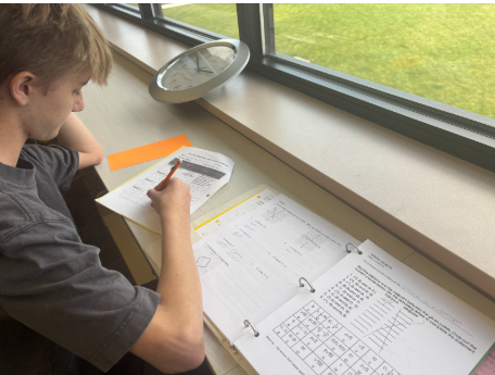 Owen Corcoran (9) works on his Honors Geometry homework during his off period on September 22nd. He diligently works on the task in the library’s silent section.
