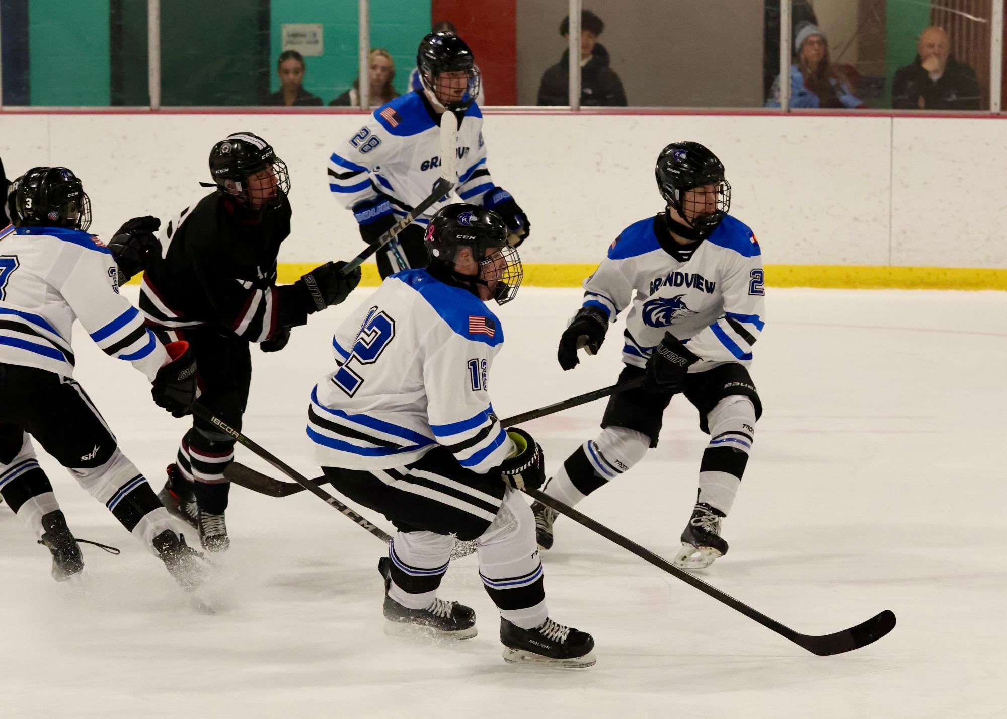 Locked in and chasing the puck — Caleb Brown, William Saunders, and Kai Pacheco push forward for Grandview as the game heats up.