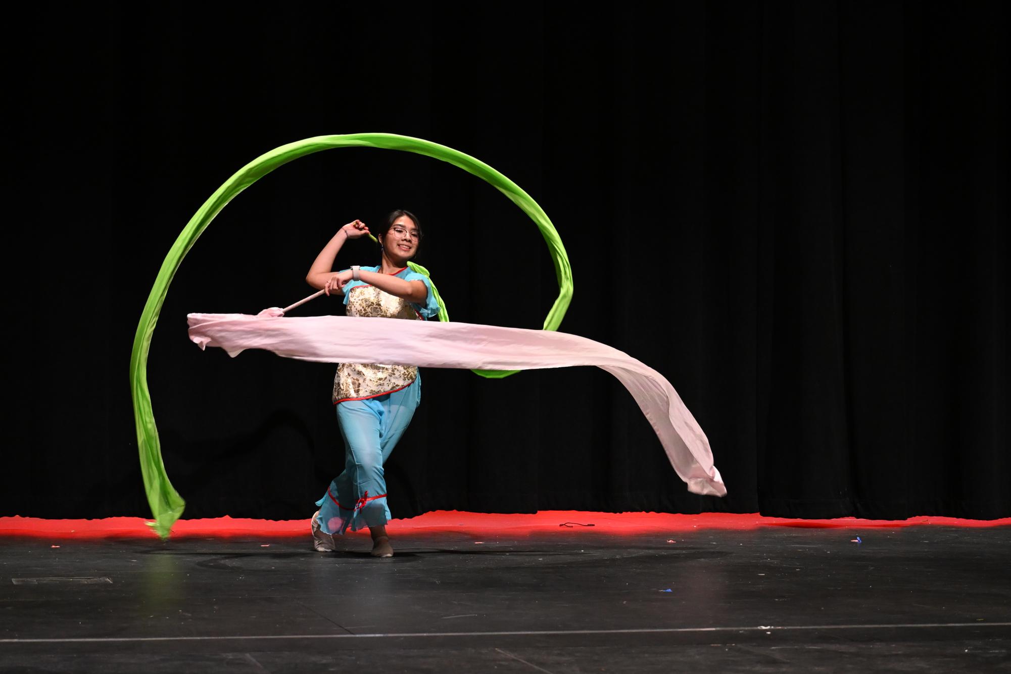 Kate Wong (11) performing a Chinese dance that includes a long fan and long ribbon.